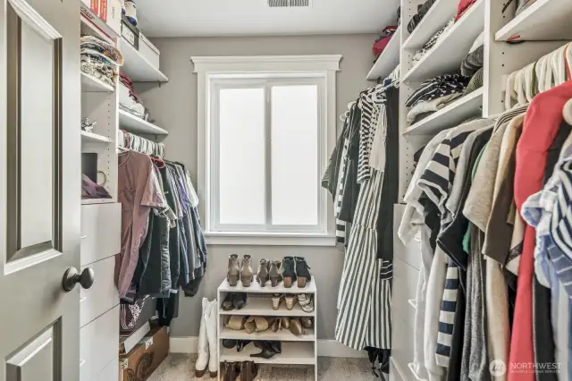 Custom organizers in the walk-in closet help you keep everything in order.