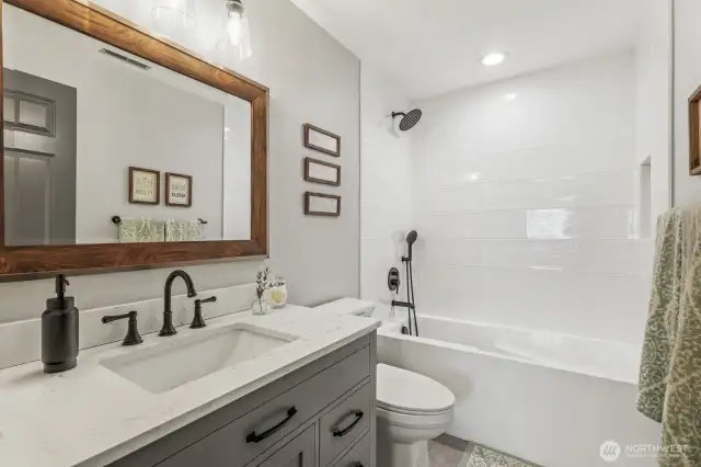 Hallway full bathroom on the upper level - also remodeled in 2021 with a new tub, shower surround, toilet, vanity, hardware and tile floors.