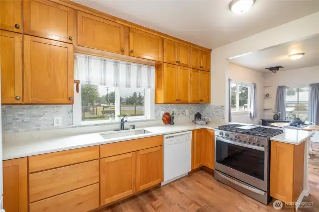 Love the window over the sink looking out to huge fenced yard; new gas stove