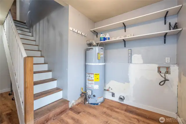 large open utility/mud room w/door leading to yard & stairs to 2nd floor