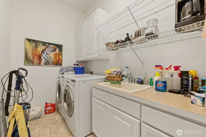The laundry room has great space; a large countertop and a utility sink highlight this space.