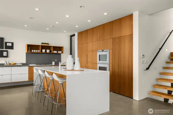 A chef’s stage: waterfall island, sculptural cabinetry, and the prestige of Sub-Zero, Miele, and Gaggenau — cooking here becomes performance art.