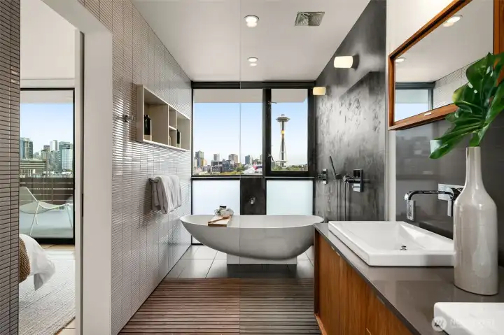 The deep soaking tub is perfectly placed before a wall of glass, inviting long pauses with skyline views as your backdrop.