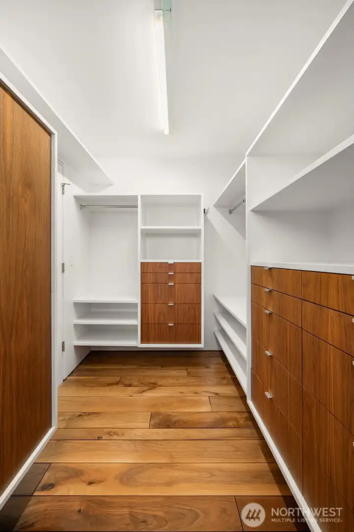 A wardrobe’s dream — spacious walk-in closet with gallery-like presentation for clothing, shoes, and accessories.