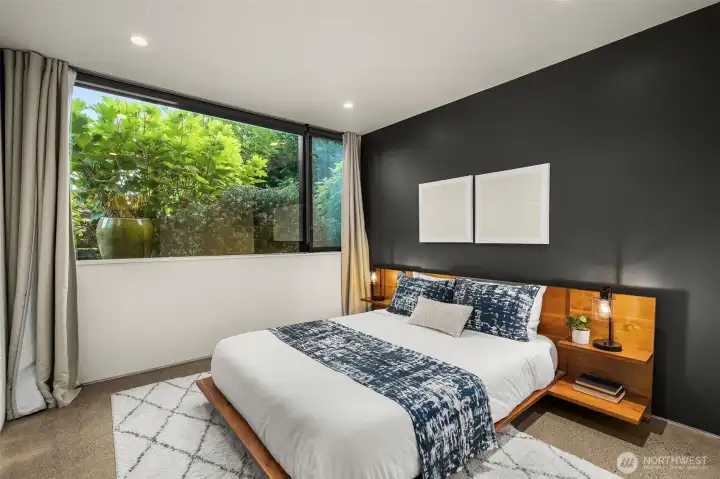 A guest bedroom where simplicity becomes luxury — framed greenery, soft light, and clean design.