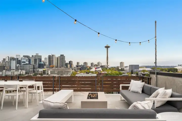 String-lit terrace where evenings extend into starlight, Seattle’s skyline twinkling just beyond.