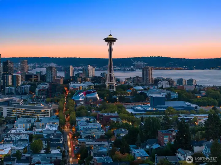 The Space Needle rises, luminous against twilight — a reminder you live in the heart of Seattle’s story.