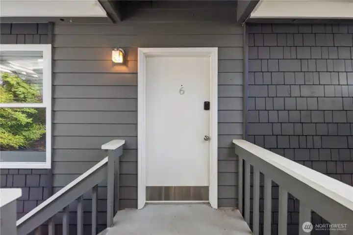 Front Entry: Private entry to the top-floor unit with fresh siding and secure keyless access. Covered stairs and lighting ensure year-round convenience and safety.