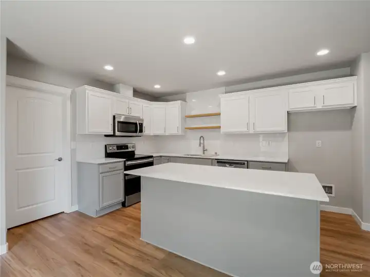 This modern, newly updated kitchen features a clean design and direct access to a pantry for everyday convenience.