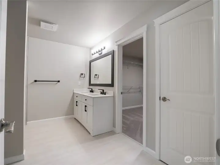 This bathroom blends bright white finishes with bold black accents, creating a clean, modern and striking contrast.
