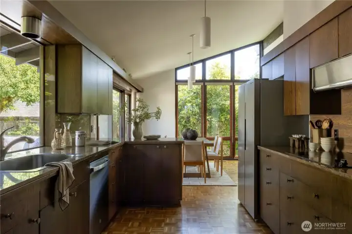 Updated kitchen with newer appliances, hardwood parquet floors, natural stone counters