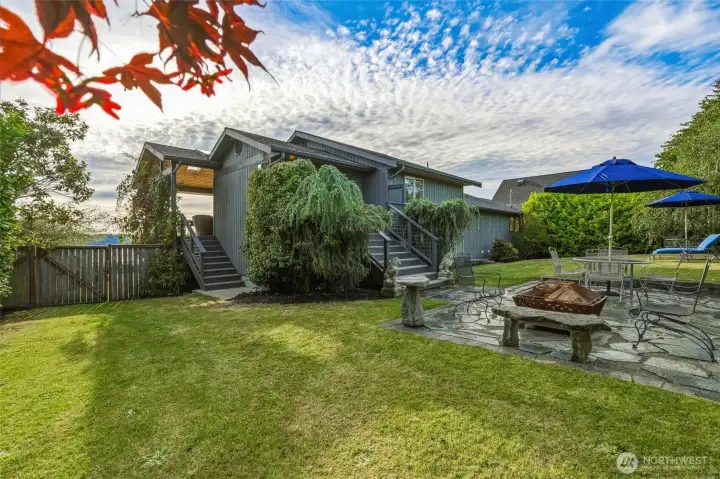 Fully fenced back yard private patio and garden area with firepit