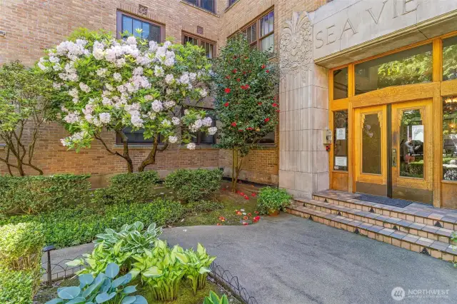 Gorgeous entryway. Unit is behind the camellia bushes depicted here. Hyper convenient building location for pet owners.