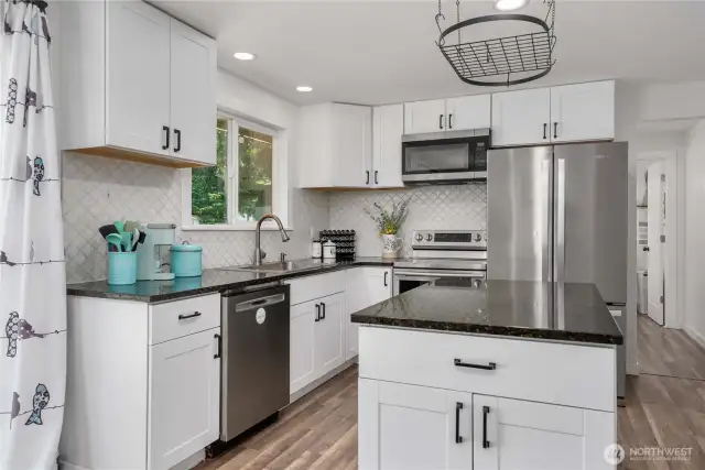 Past the kitchen is the Primary bedroom, bathroom, and utility room