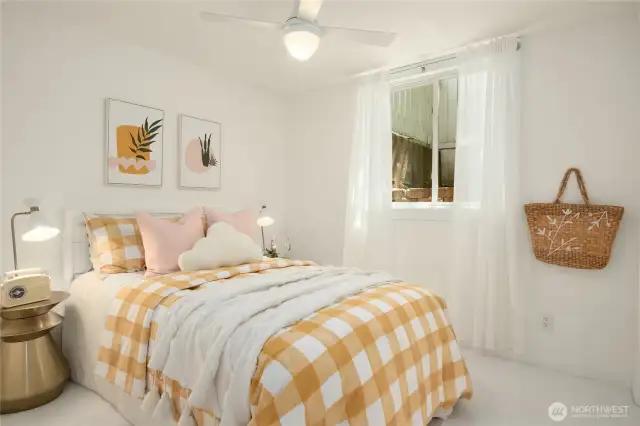 The second of the three bedrooms located downstairs with a daylight window and new carpet.