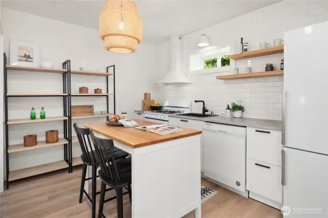 This efficient kitchen features gas cooking and a full tiled backsplash with open shelving along with a great breakfast bar.