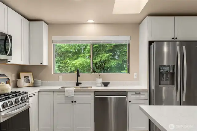 Large kitchen window overlooks the back yard