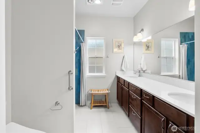 Bathroom in primary bedroom with wheelchair accessible roll-in shower