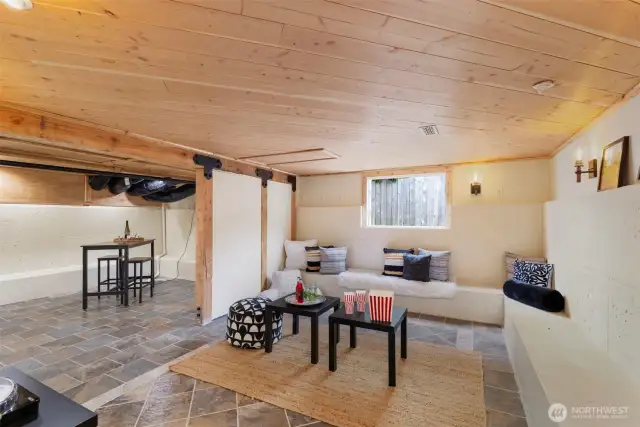 Finished basement area with built in seating, sliding barn door and gorgous tongue and groove ceiling.