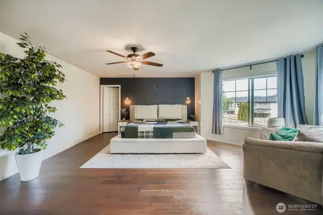 Looking at large primary bedroom from bathroom entry