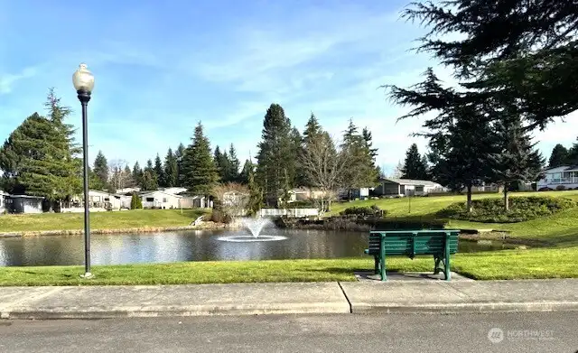 Lovely, park-like grounds featuring a serene pond and a charming water feature.