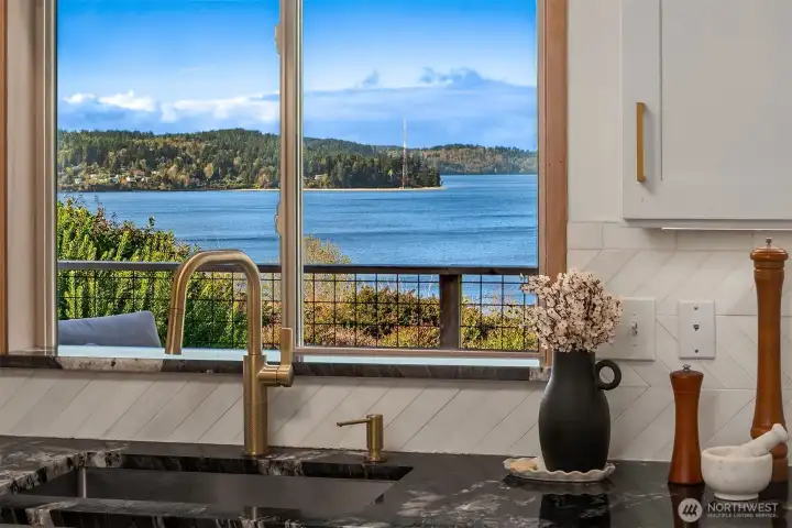 Kitchen window framing stunning waterfront views, bringing the outdoors in.