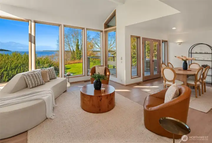 Spacious living area with wall of windows and seamless indoor-outdoor connection to the deck.