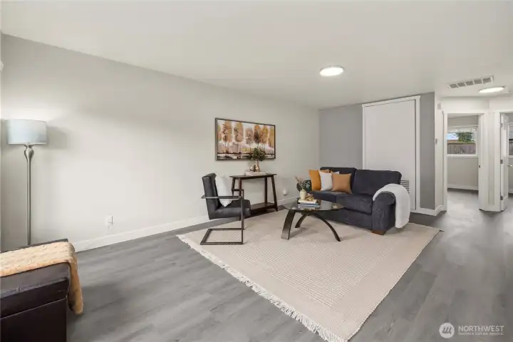 Living area with new plank flooring, fixtures, and paint
