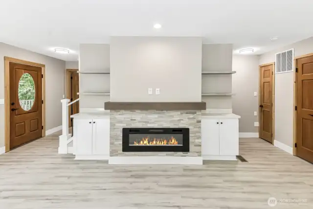 Electric fireplace with some built ins. Front door to the left.