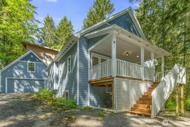 Front view of home. Stairs lead to front entrance to home.