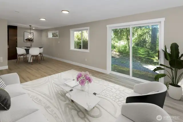 Virtually staged. Basement living area with peak into dining room and sliding glass door to private entrance to home.