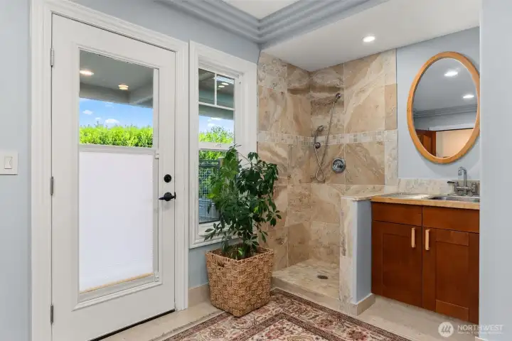 Door to North facing patio and garden beds. Shower for rinsing after swimming in the saltwater and or possible dog washing station.