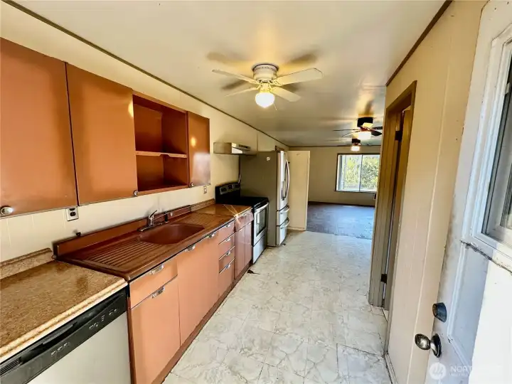 Galley style kitchen with stainless appliances.