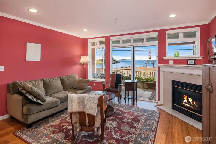 Living rooms with inviting gas fireplace and tall windows facing west that bring in lots of sunshine and amazing views of the Sound and Olympics