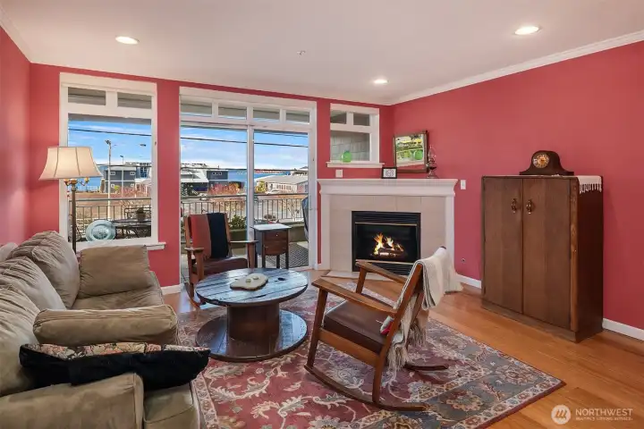 Living rooms with inviting gas fireplace and tall windows facing west that bring in lots of sunshine and amazing views of the Sound and Olympics