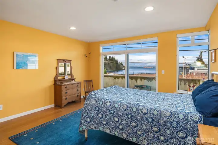 Large primary bedroom with floor-to-ceiling windows facing west for great views and a private deck