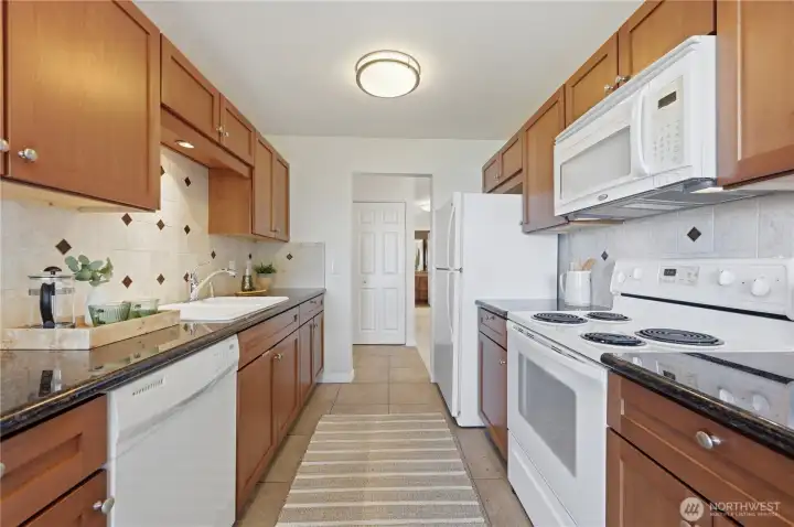 The kitchen from the dining area looking to the entry of the home & coat closet.