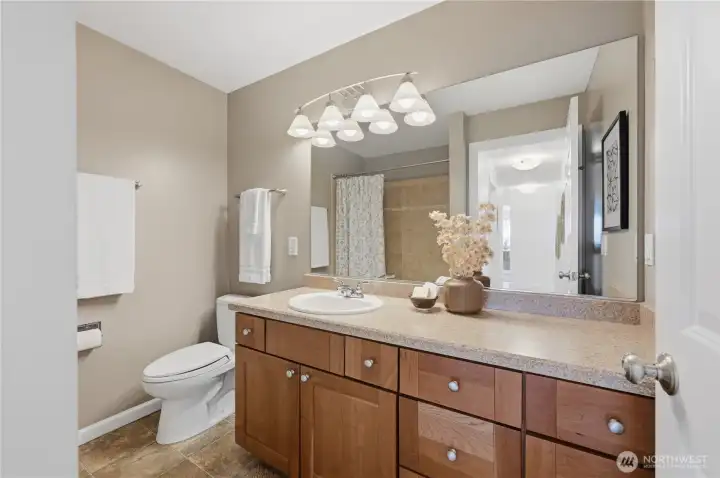 Pretty guest vanity bath with tile soaking tub.