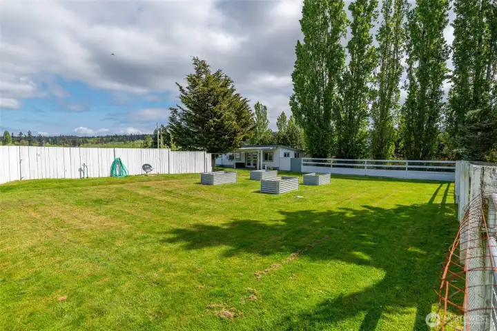 Raised garden beds. View looking towards the guest cottage with the barn behind the photographer