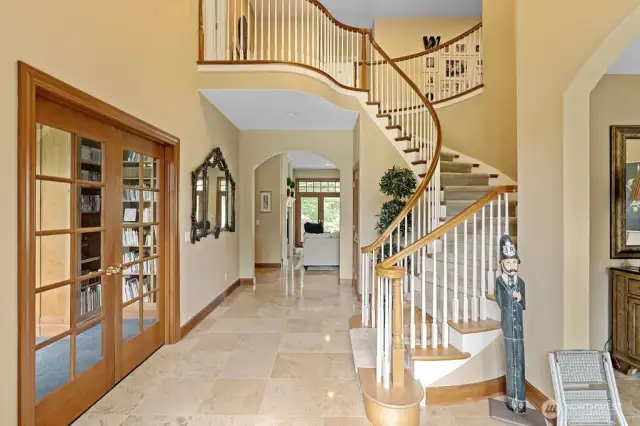 The grand entry. To the left is the library/study. The Italian porcelain tile leads to the living room. French doors open out to the patio, back yard, lakeshore and golf course. The sweeping stairway is a fine example of the exceptional archetectural design of this home.