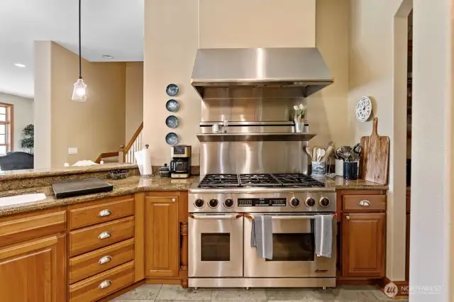 The Dacor gas range and commercial grade hood are a focal point of the gourmet kitchen.
