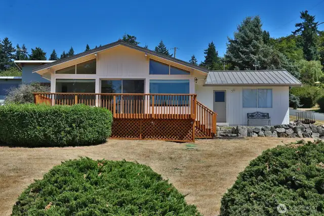 Freshly painted (2025) exterior. Corner lot and a short stroll to the community beach and boat launch. The door and window to the far right belong to the 2-car garage which has a half bath to the left upon entry. This is the West side of your home.