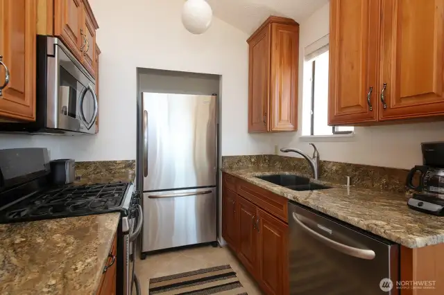 The Sellers love to cook and designed their kitchen accordingly with a propane oven/range. The hot water heater is located behind the wall adjacent to the refrigerator (accessible by pulling the fridge out). Your sink window has a view!