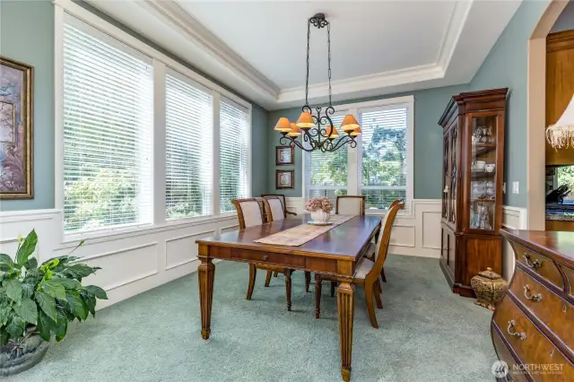 Formal dining room with tray ceiling and large windows offer an elegant yet comfortable space to dine with friends and family
