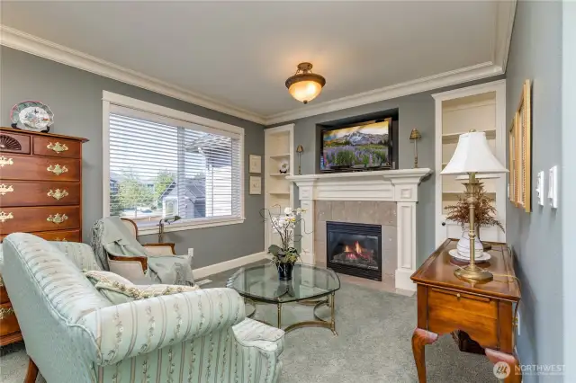Primary suite sitting area with custom gas fireplace and built-in shelving. The perfect place to start or finish the day!