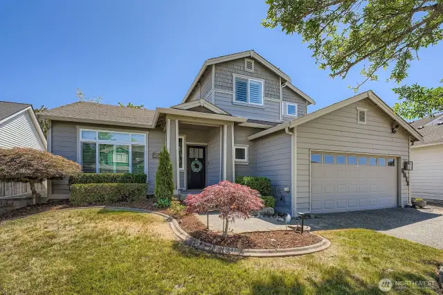 Front of home with mature landscaping and sprinkler system