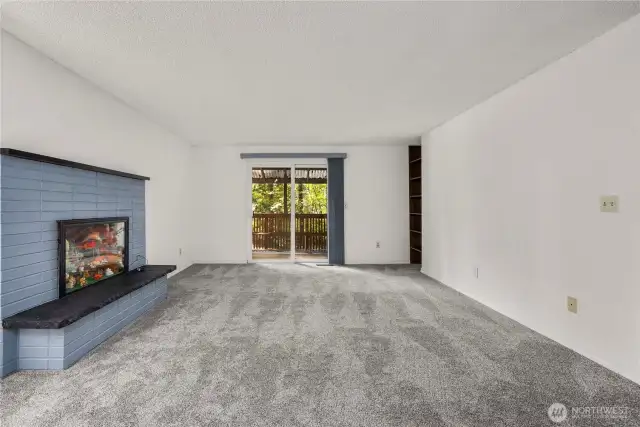 Living room, wood burning FP currently used for curio display. Deck overlooking property
