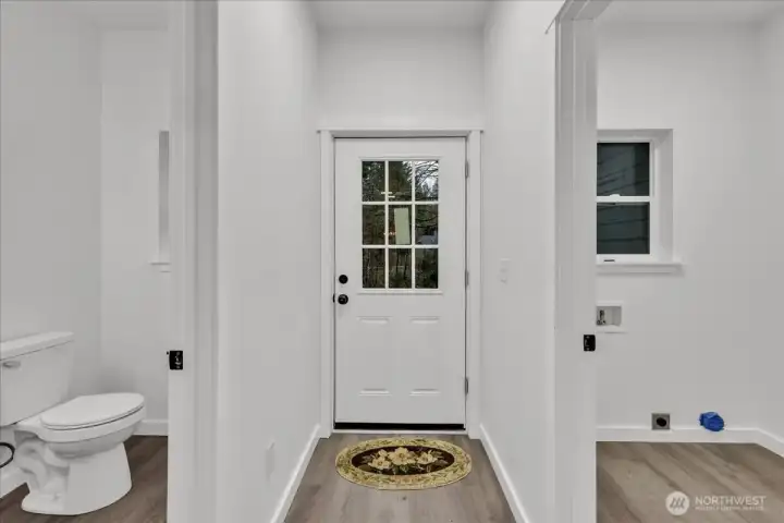 Door leading from side of home into kitchen. 1/2 bath on the left laundry room and garage entrance to the left.