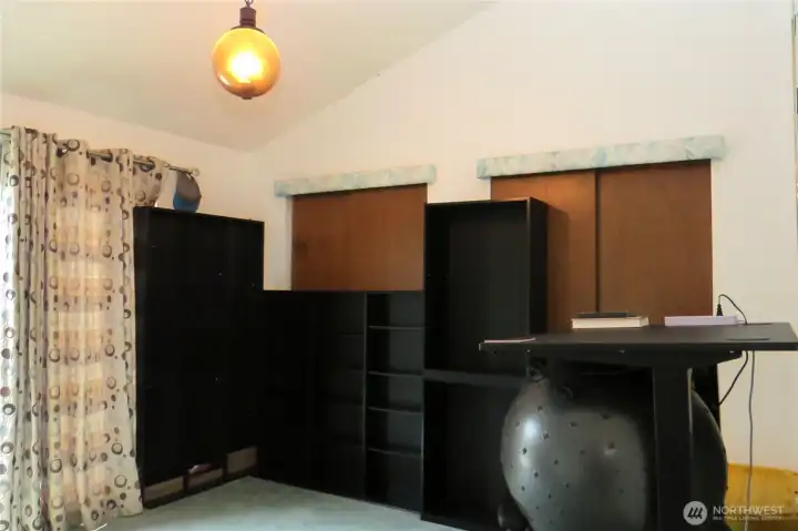 MOVING DOWN THE HALLWAY TO THE PRIMARY BEDROOM WITH HIS AND HERS CLOSETS AND VAULTED CEILINGS!