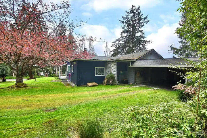 A carport behind the house offers flexible storage for vehicles and more.
